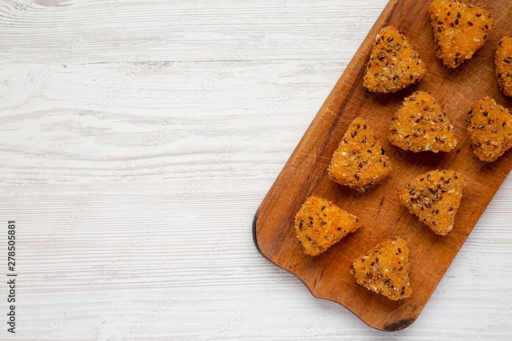 Overhead view, fried camembert on a rustic wooden board on a white wooden background. Flat lay, top view, from above. Copy space. Overhead view, fried camembert on a rustic wooden board on a white wooden background. Flat lay, top view, from above. Copy space.
