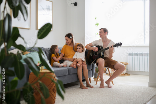 happy family with two children sings with guitar