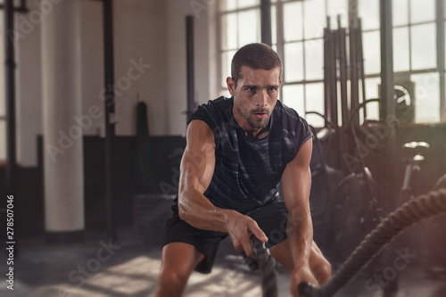 Fototapeta Naklejka Na Ścianę i Meble -  Man doing crossfit exercise with rope