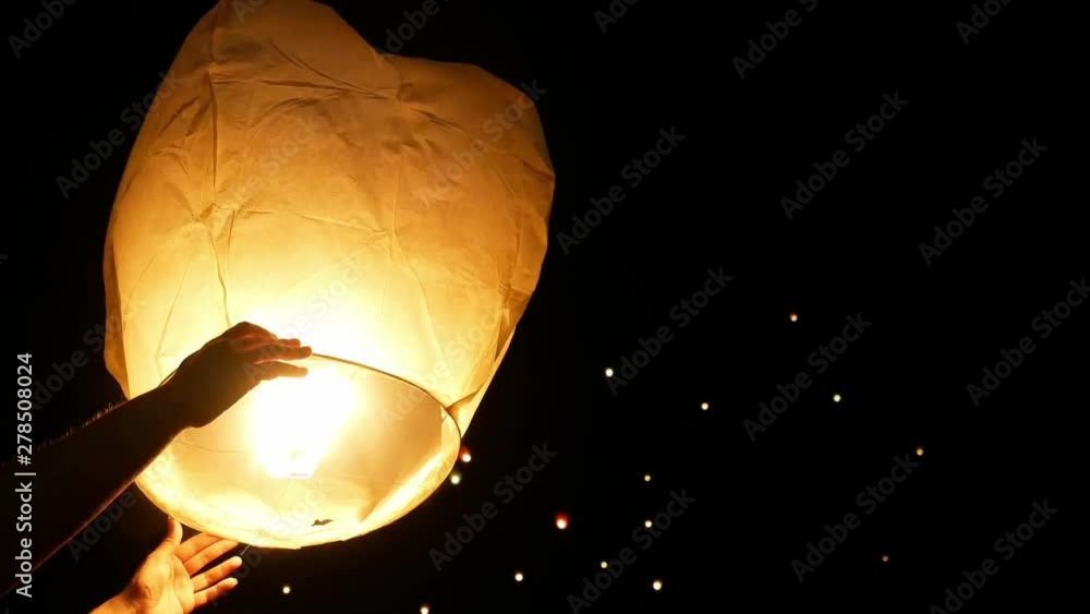 Floating Lanterns Are Lit And Hands Are Letting Go Of Them. Chinese
