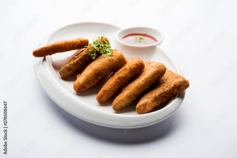 crispy Potato triangles or batata vada covered with bread crumbs and then deep fried. served with tomato ketchup. selective focus crispy Potato triangles or batata vada covered with bread crumbs and then deep fried. served with tomato ketchup. selective focus