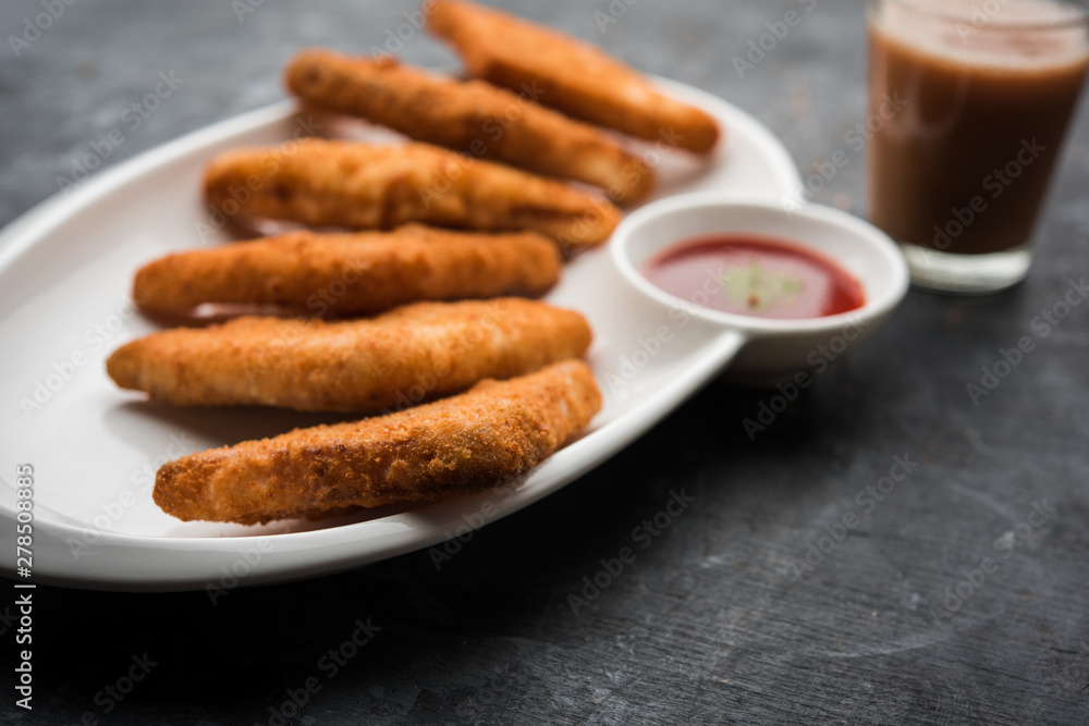 crispy Potato triangles or batata vada covered with bread crumbs and then deep fried. served with tomato ketchup. selective focus crispy Potato triangles or batata vada covered with bread crumbs and then deep fried. served with tomato ketchup. selective focus