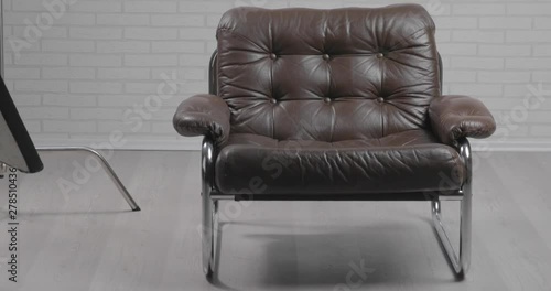 Photo studio with leather chair, c-stand, bouncing desk and octabox / moving shot photo