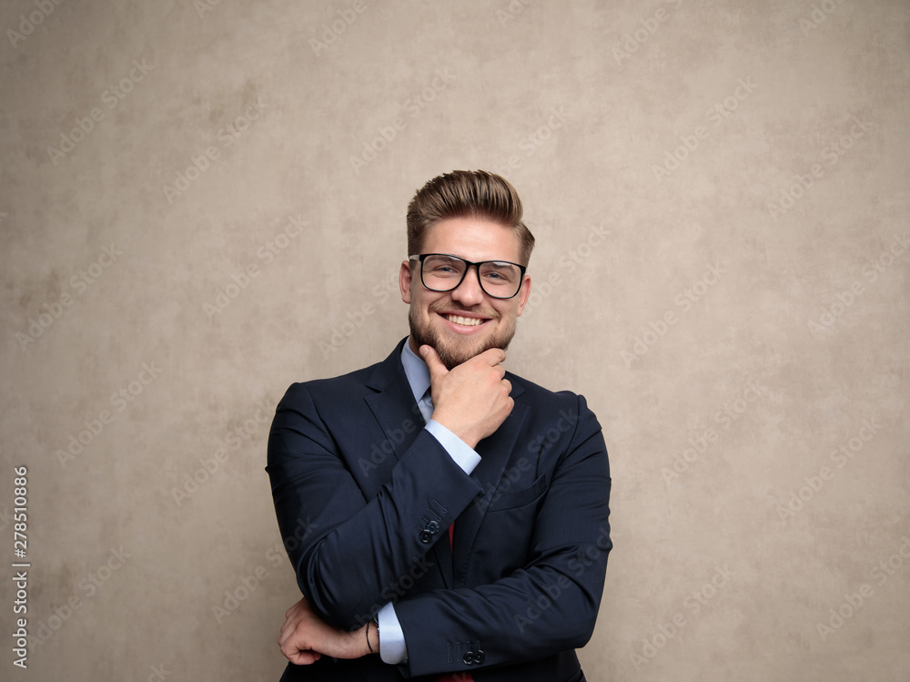 Jolly businessman holding his hand on his chin Jolly businessman holding his hand on his chin