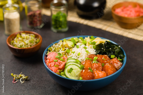 Hawaiian salmon poke bowl with seaweed, avocado, sesame seeds.