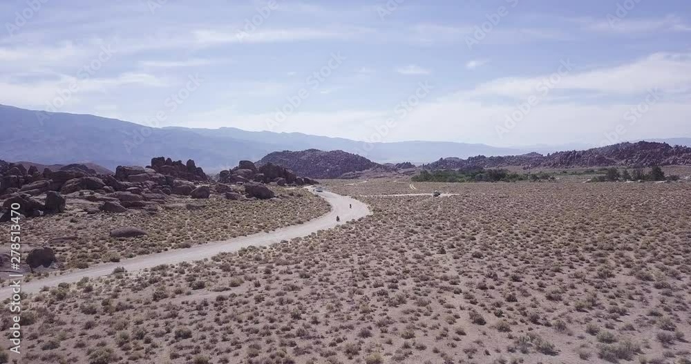 bikers on the journey on the Road in the Alabama Hills, near Lone Pine, best friends adventure, aerial drone dolly in wide shot bikers on the journey on the Road in the Alabama Hills, near Lone Pine, best friends adventure, aerial drone dolly in wide shot