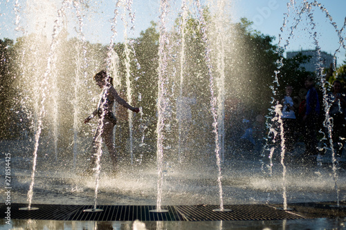A girl is walking in a fountain 
