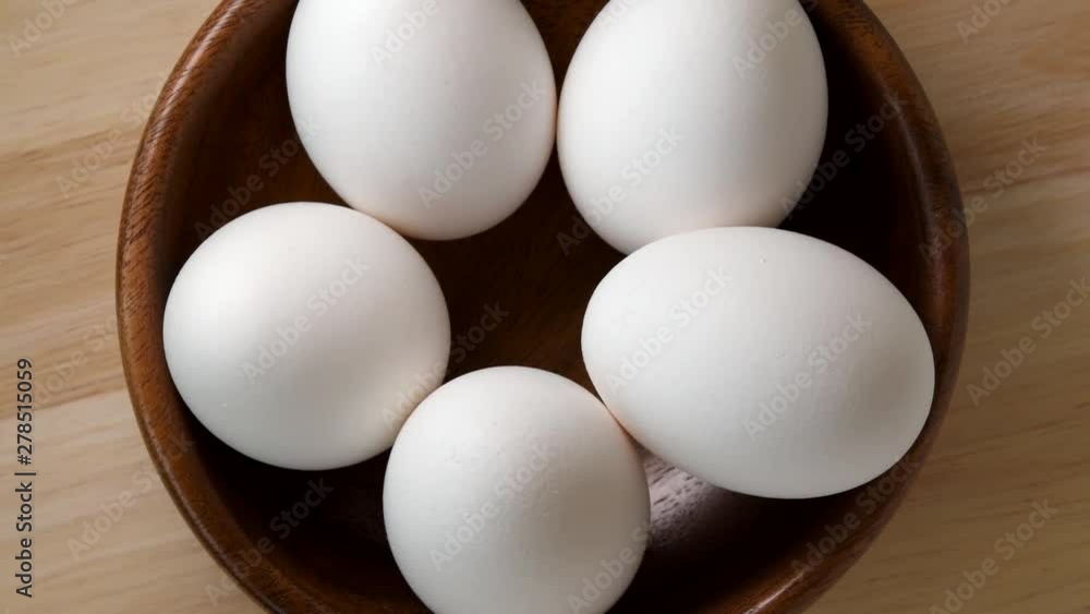 Eggs rotating in wooden bowl top view Eggs rotating in wooden bowl top view