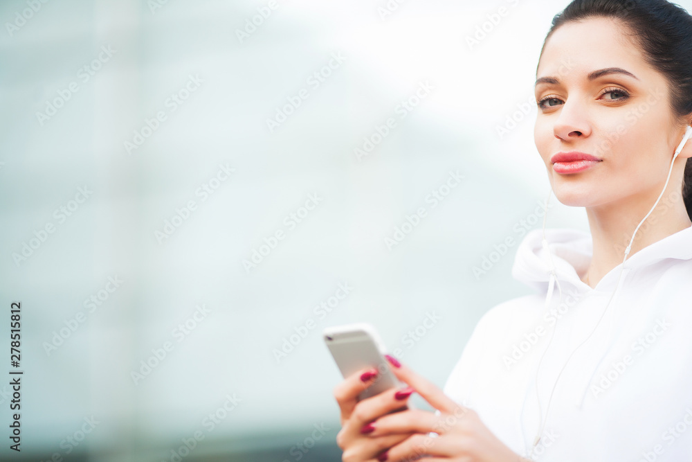 Photo of Joyful Fitness Woman 30s in Sportswear Touching Bluetooth Earpod and Holding Mobile Phone, While Resting in Green Park Photo of Joyful Fitness Woman 30s in Sportswear Touching Bluetooth Earpod and Holding Mobile Phone, While Resting in Green Park