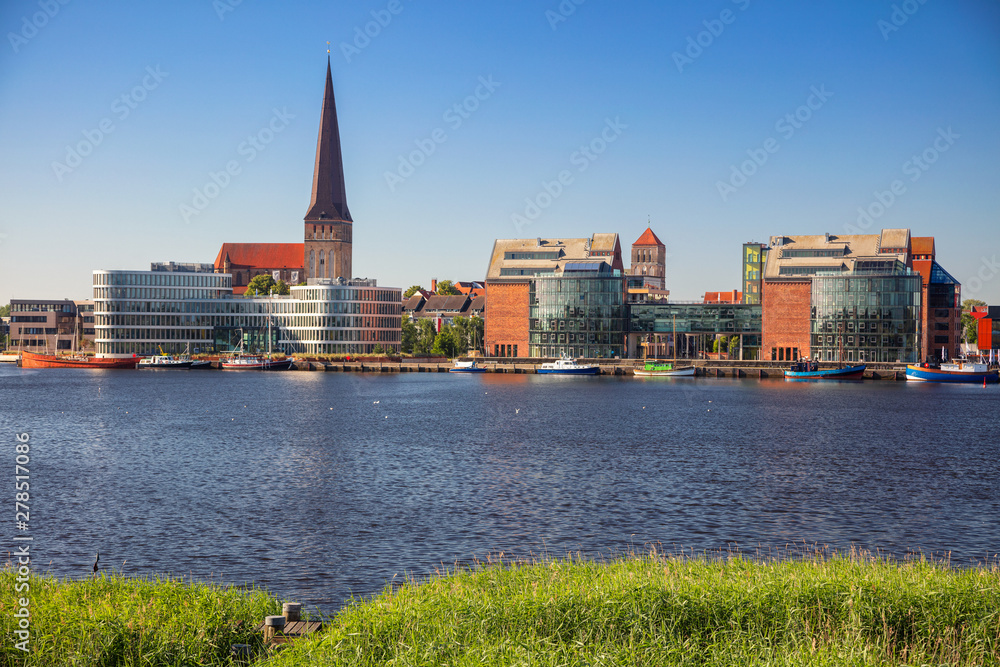 Rostock, Germany. Cityscape image of Rostock riverside with St. Peter's Church during sunny summer day.