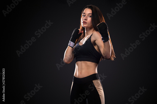 Sportsman, woman boxer fighting in gloves on black background. Boxing and fitness concept. © Mike Orlov