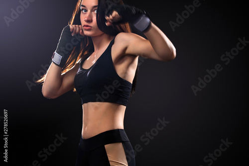 Sportsman, woman boxer fighting in gloves on black background. Boxing and fitness concept. © Mike Orlov