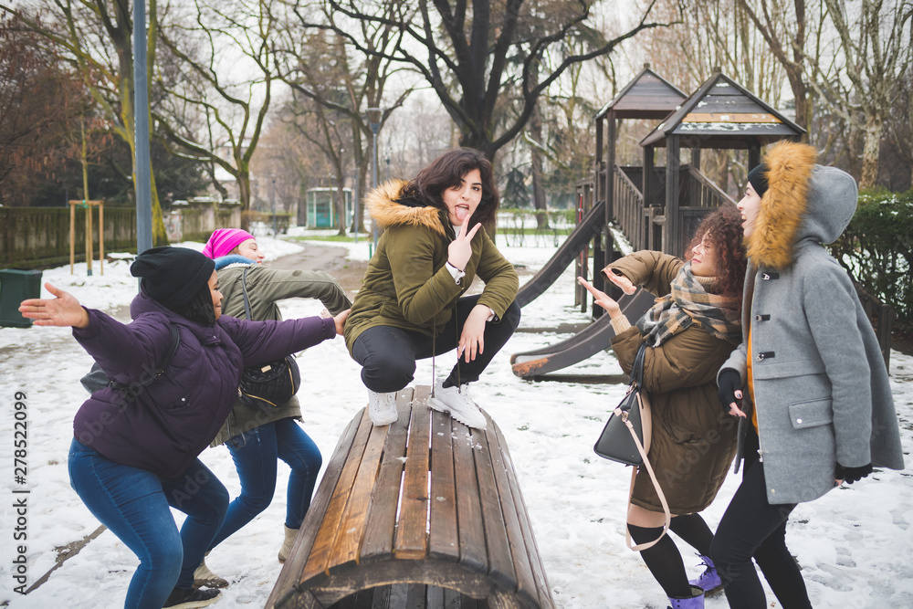 Group of young women enjoying in park during winter