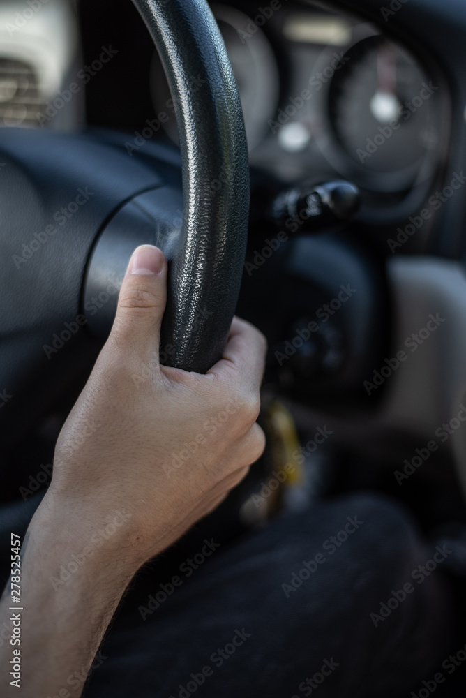 Mano de hombre cogiendo un volante de coche mientras conduce Mano de hombre cogiendo un volante de coche mientras conduce