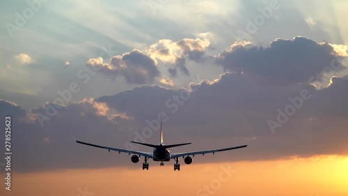 Tracking shot of airplane landing in beautiful morning sky photo