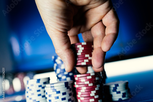 Fotografie Lucky player stacking poker chips at casino