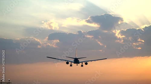 Airplane landing at sunrise photo