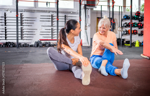 Senior woman workout with trainer at the gym photo