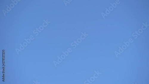 Airplane flying over in clear blue sky