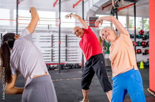 Senior people workout with personal trainer in rehabilitation center