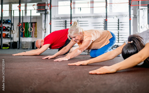 Senior people workout with personal trainer at the gym