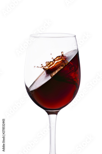 splash with crown of red wine in glass isolated on white background.