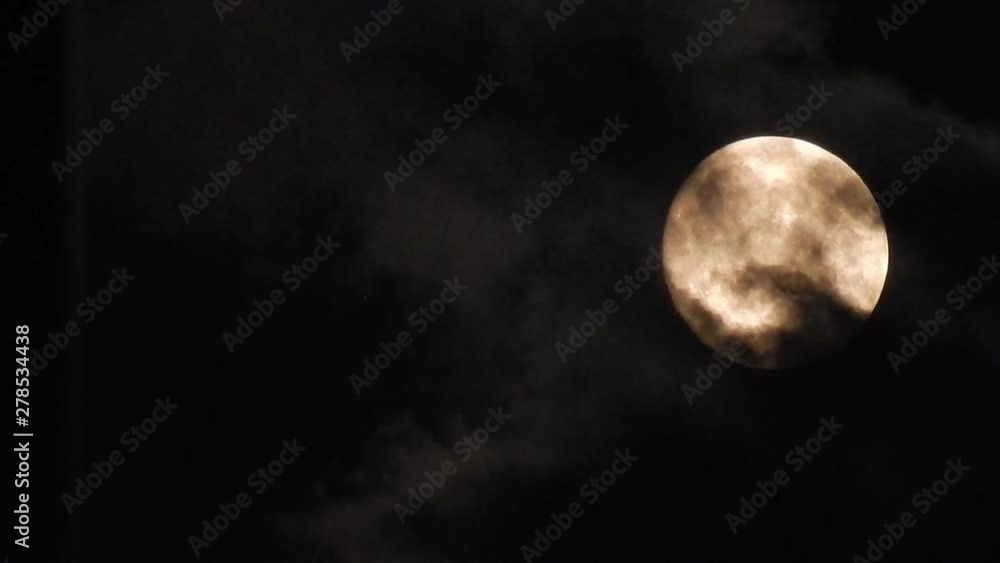 Dark clouds passing in front of spooky illuminated moon surface. Dark clouds passing in front of spooky illuminated moon surface.