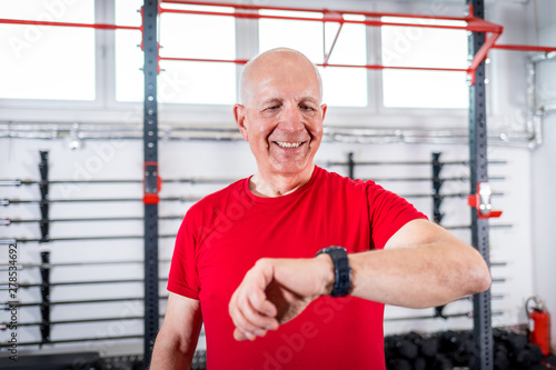 Senior man at the gym using smartwatch