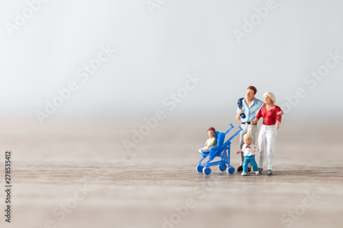 Miniature people : Parents with children walking outdoor , Happy family concept