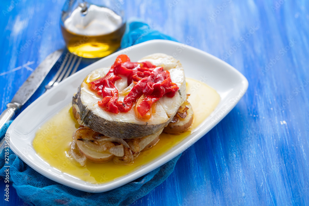 boiled fish with vegetables, olive oil in dish on blue wooden background boiled fish with vegetables, olive oil in dish on blue wooden background