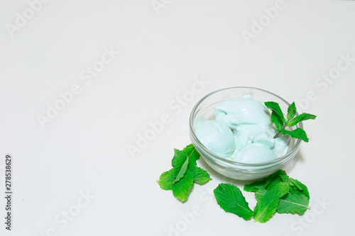 Green tropical ice cream with mine leaves on white background with copy space – Natural iced creamy refreshment made at home – Healthy sweet and tasty cold snack