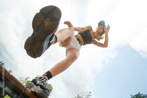 Close-up shot of girl's shoes. Big boots bottom view. Young sporty white caucasian teenage girl in a black cap and white shorts in the park on a sunny day in summer.