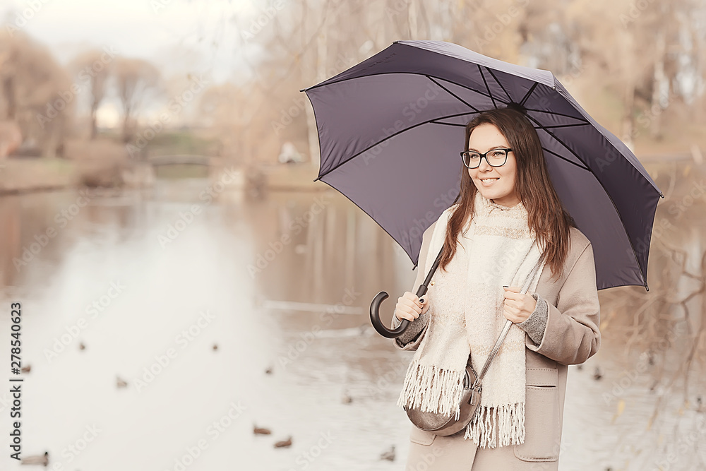 Fototapeta premium long background girl umbrella / horizontal view rainy autumn day young woman with umbrella