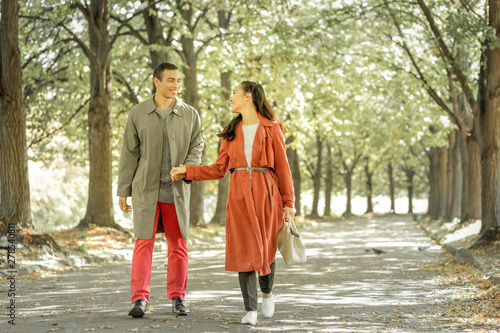 Pleasant young couple holding hands during walk