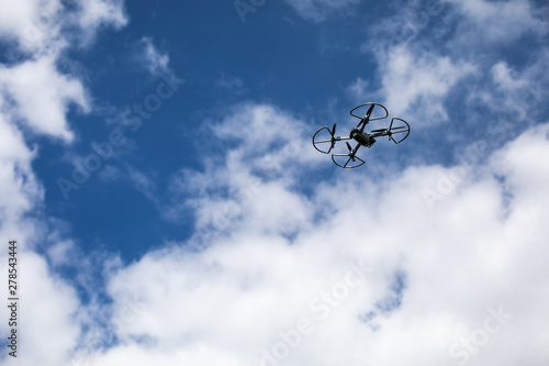 drone quadcopter with digital camera on blue sky background