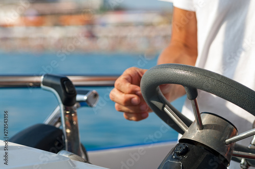 Close-up of a man drives a yacht.
