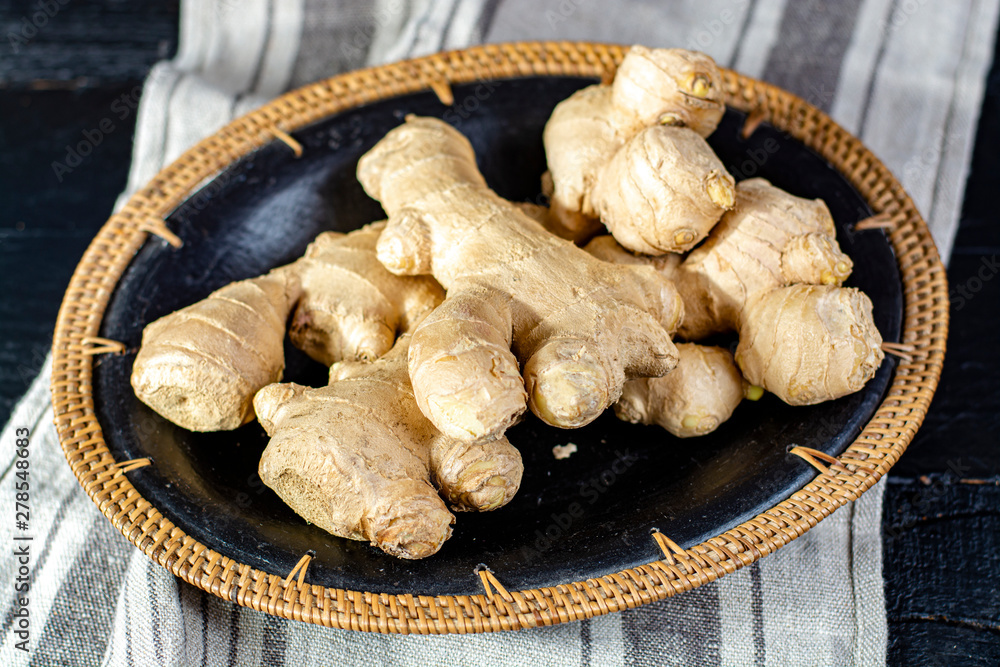 Fototapeta premium Fresh ginger roots close up on linnen napkin background