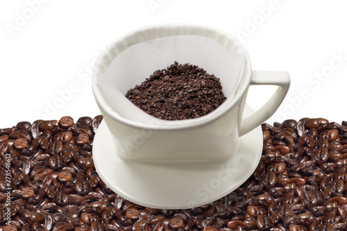 Cup of drip coffee with paper filter tool on the group of coffee beans