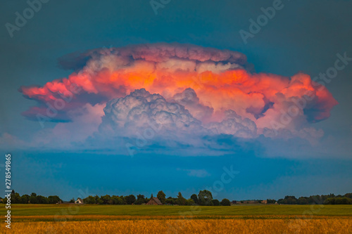 Tableau sur toile Severe pulse thunderstorm Cumulonimbus clouds iluminated by evening red light, a