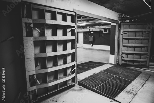 Konstfotografi Details with the heavy metal doors of a nuclear explosion shelter (fallout shelter), four stories below ground in a deep underground parking place - black and white