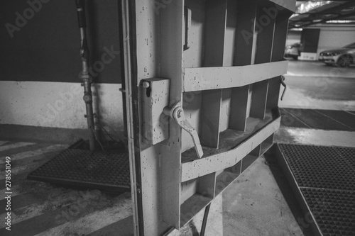 Canvastavla Details with the heavy metal doors of a nuclear explosion shelter (fallout shelter), four stories below ground in a deep underground parking place - black and white
