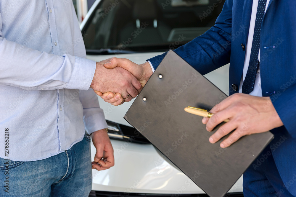 Handshakes about car buy deal close up