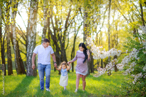 people concept. friendly family walks in a beautiful summer park along the riverbank