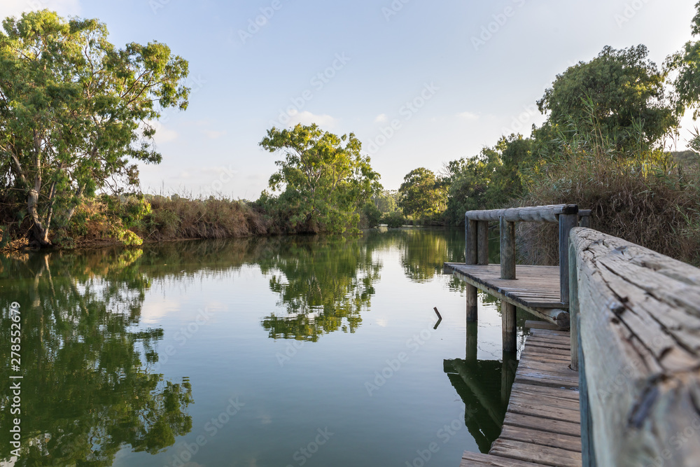 Panoramic  view at the setting sun on the remains of a wooden pier on the bank of the Alexander river, near Kfar Vitkin settlement in northern Israel