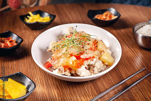 Close up korean traditional food with kimchi on wooden background. Korean rice with onions, red sauce and sesame, chicken meat. Traditional asian cuisine. Lunch. Healthy food