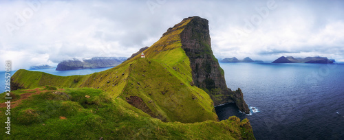фотография Small lighthouse located near huge cliffs on island of Kalsoy, Faroe Islands