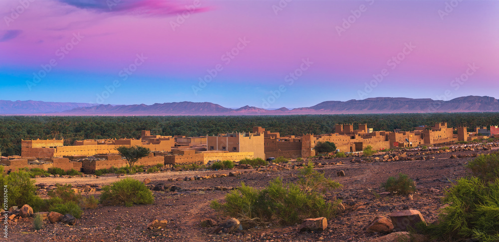 Sunset above a moroccan village with Atlas mountains in the background