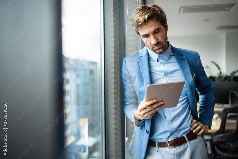Portrait of confident young businessman using digital tablet Portrait of confident young businessman using digital tablet