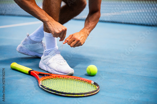 Tennis athlete player getting ready tying shoe laces during game on outdoor © NDABCREATIVITY