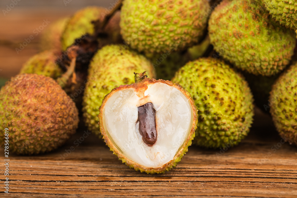 Fresh lychees on a wooden board background Fresh lychees on a wooden board background